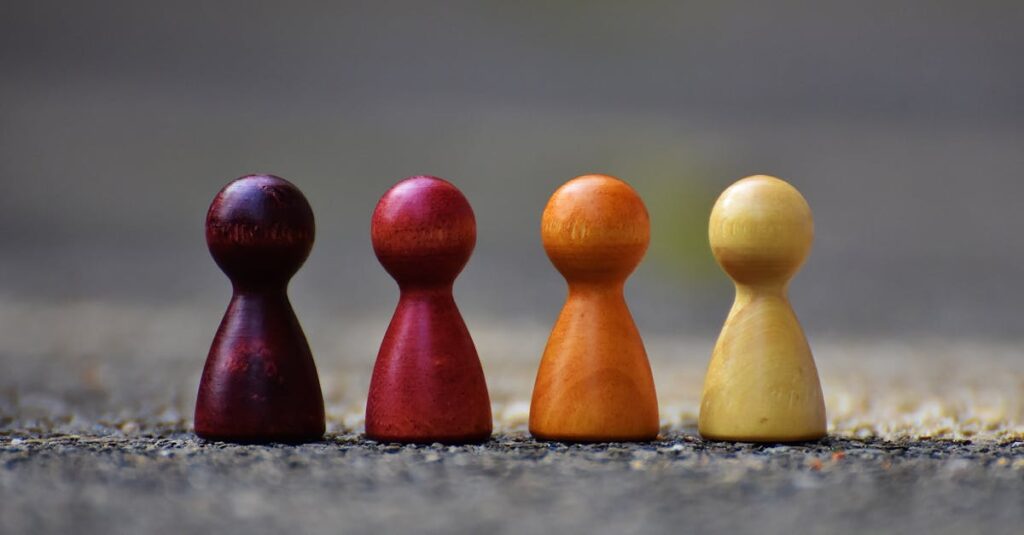Close-up of four colorful wooden pawn pieces arranged in a row.